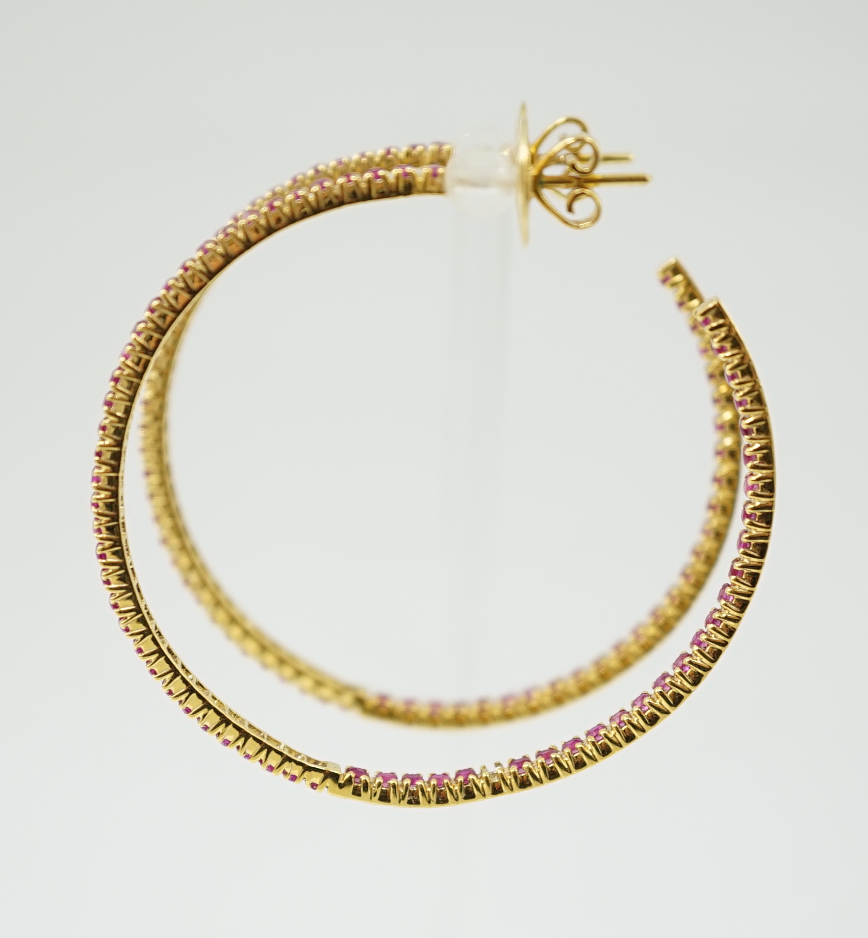 A large pair of gold and ruby chip set hoop earrings